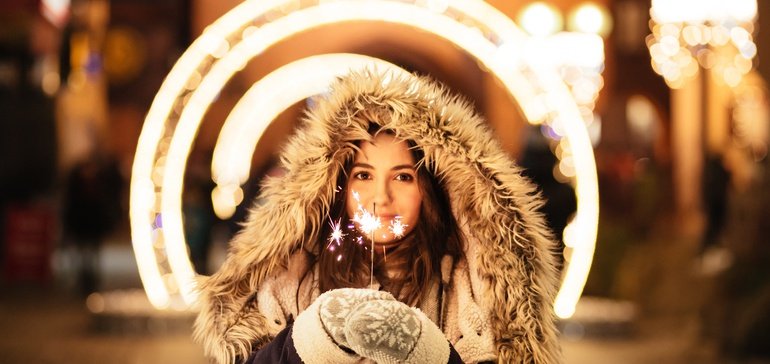 lady holding sparkling candle with lights